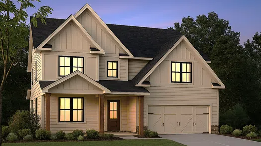 Two-story modern suburban house with lit windows, front porch, and attached garage during twilight.